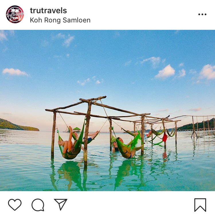 girls in sea hammocks with bright blue water and blue sky behind