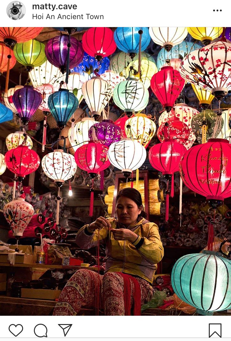 Colourful lantern stall in Vietnam with lady sat making lanterns