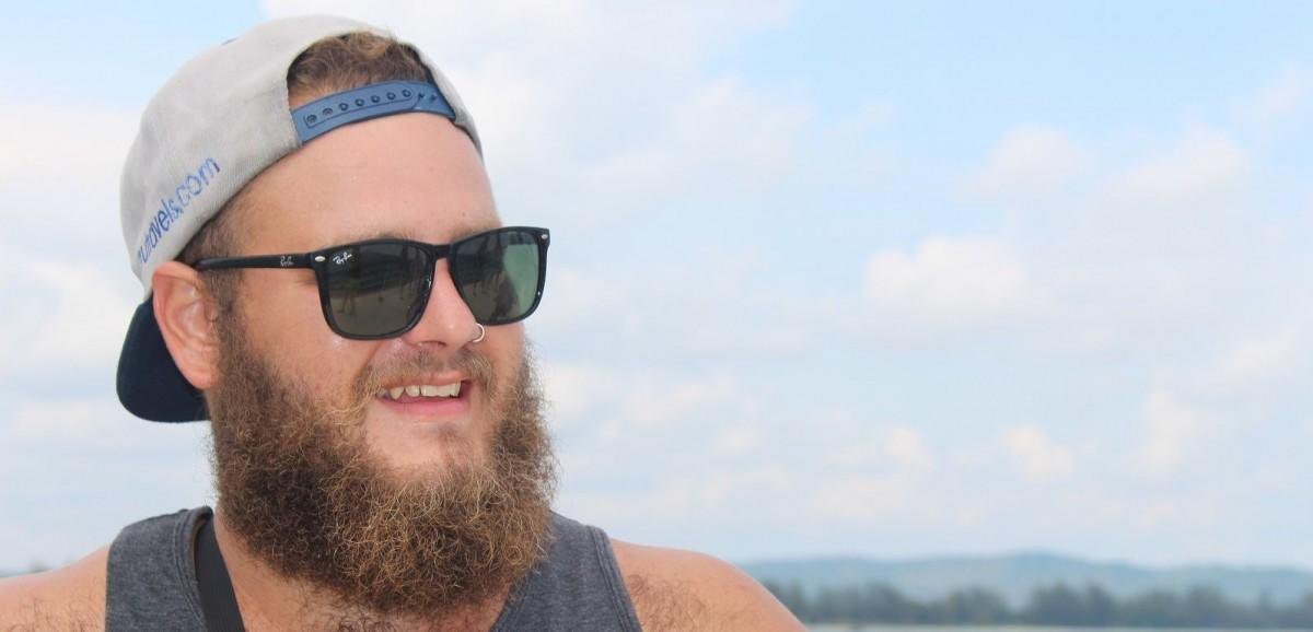man with long beard wearing sunglasses and hat smiling