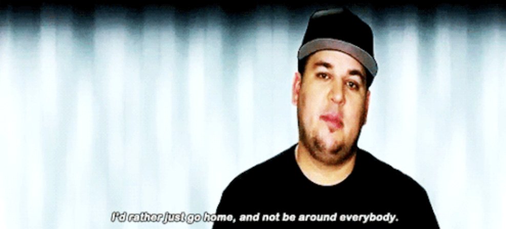 Rob Kardashian sitting in front of blank wall wearing Hat looking sad