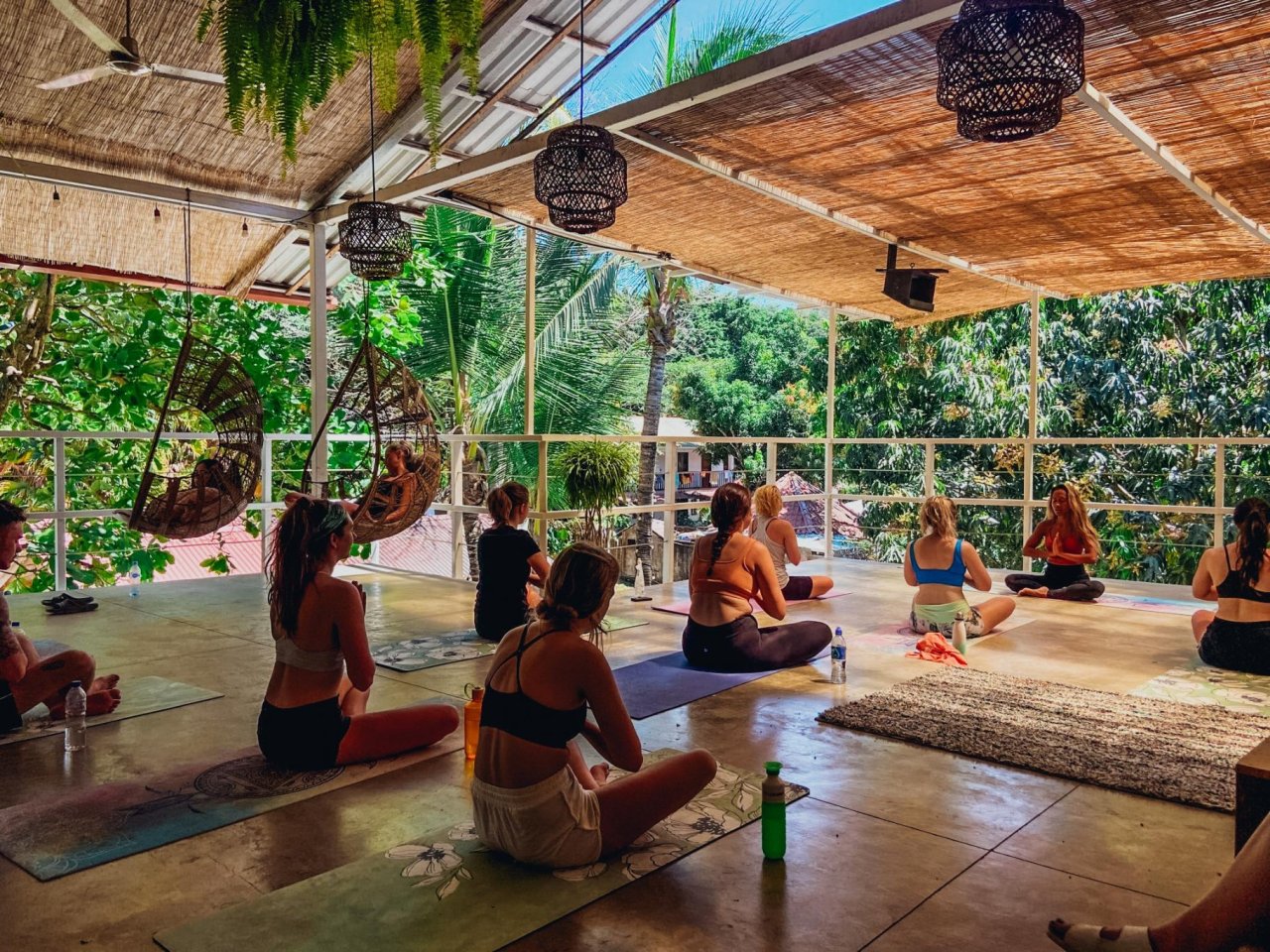People sat on exercise mats taking part in a group Yoga session.