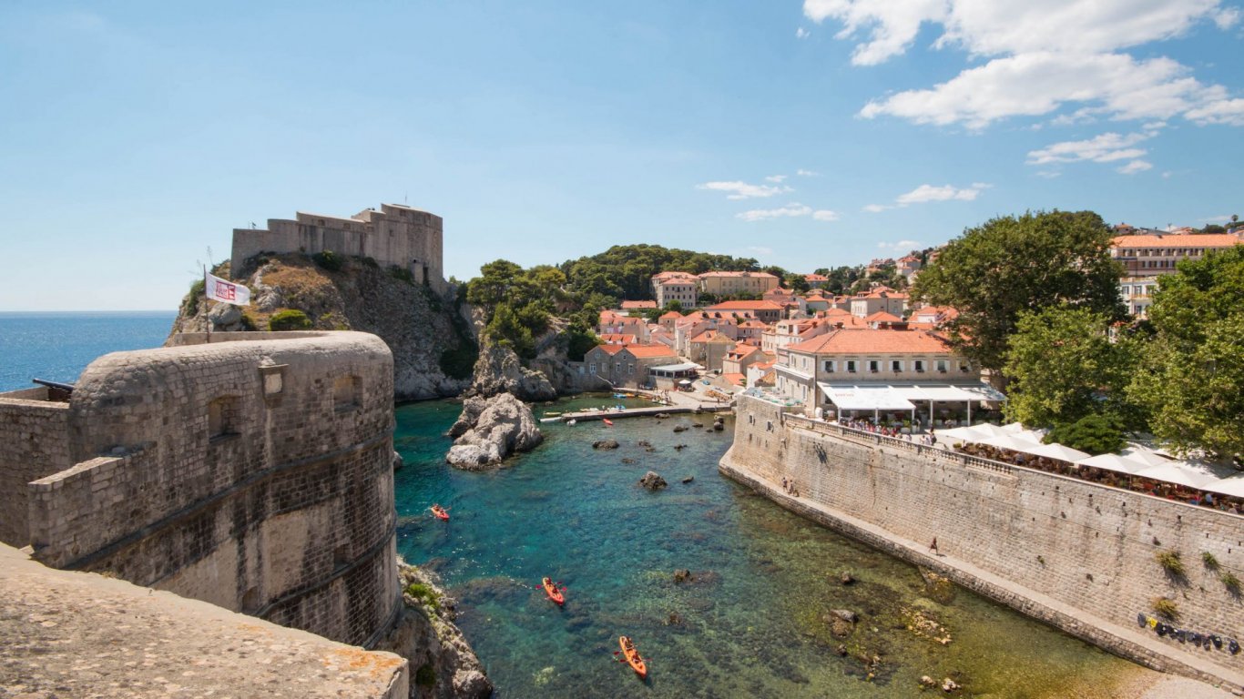 A photo of the coast in Dubrovnik Croatia, with clear blue water and historical architecture