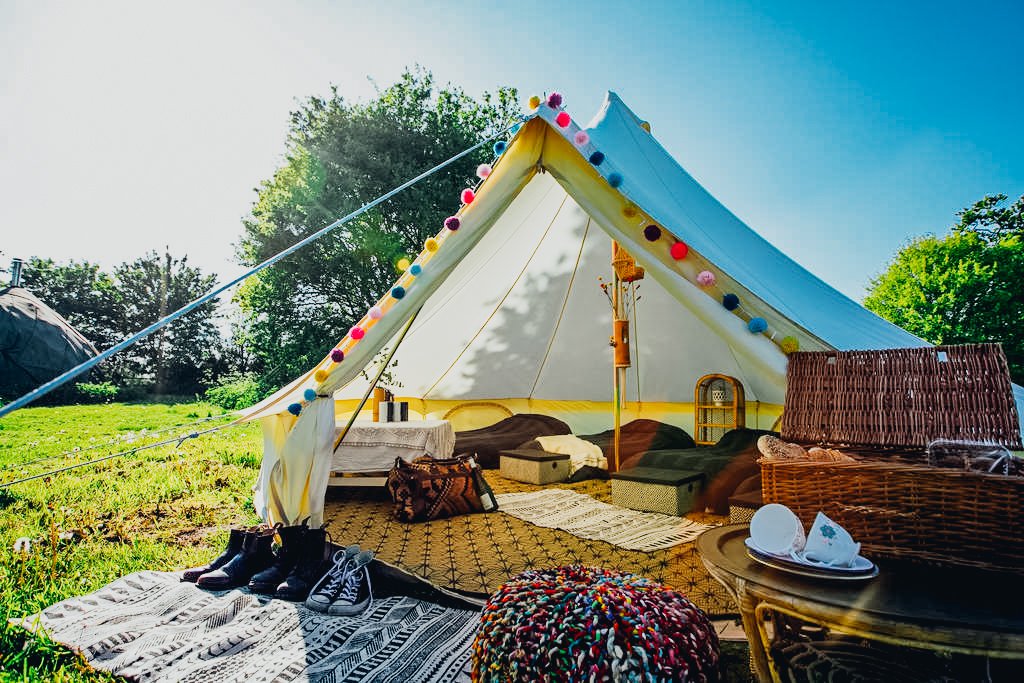 Large Teepee Glamping tent in open field with two beds and picnic table set