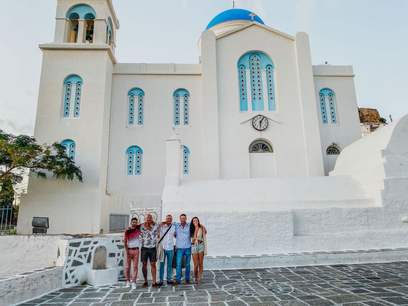 A group of five infront of a white and blue church in Ios, Greece