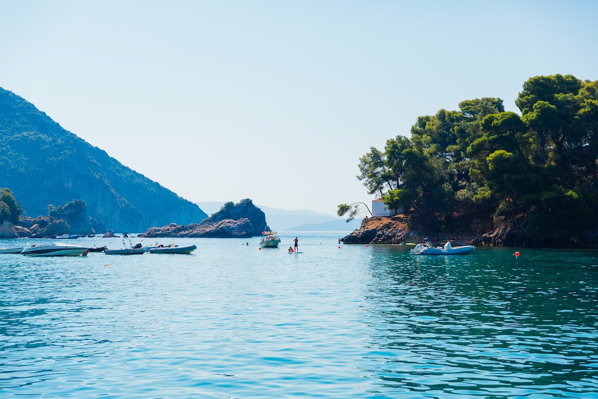 A scenic photo of the turquoise ocean and greenery in Lakka, Paxos, Greece