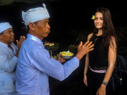 Local Balinese man giving flower to girl