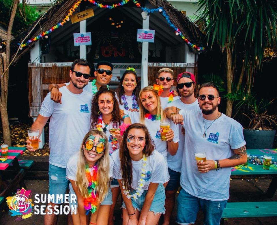 Group photo of TruCrew at summer session party wearing colourful flowers and sunglasses