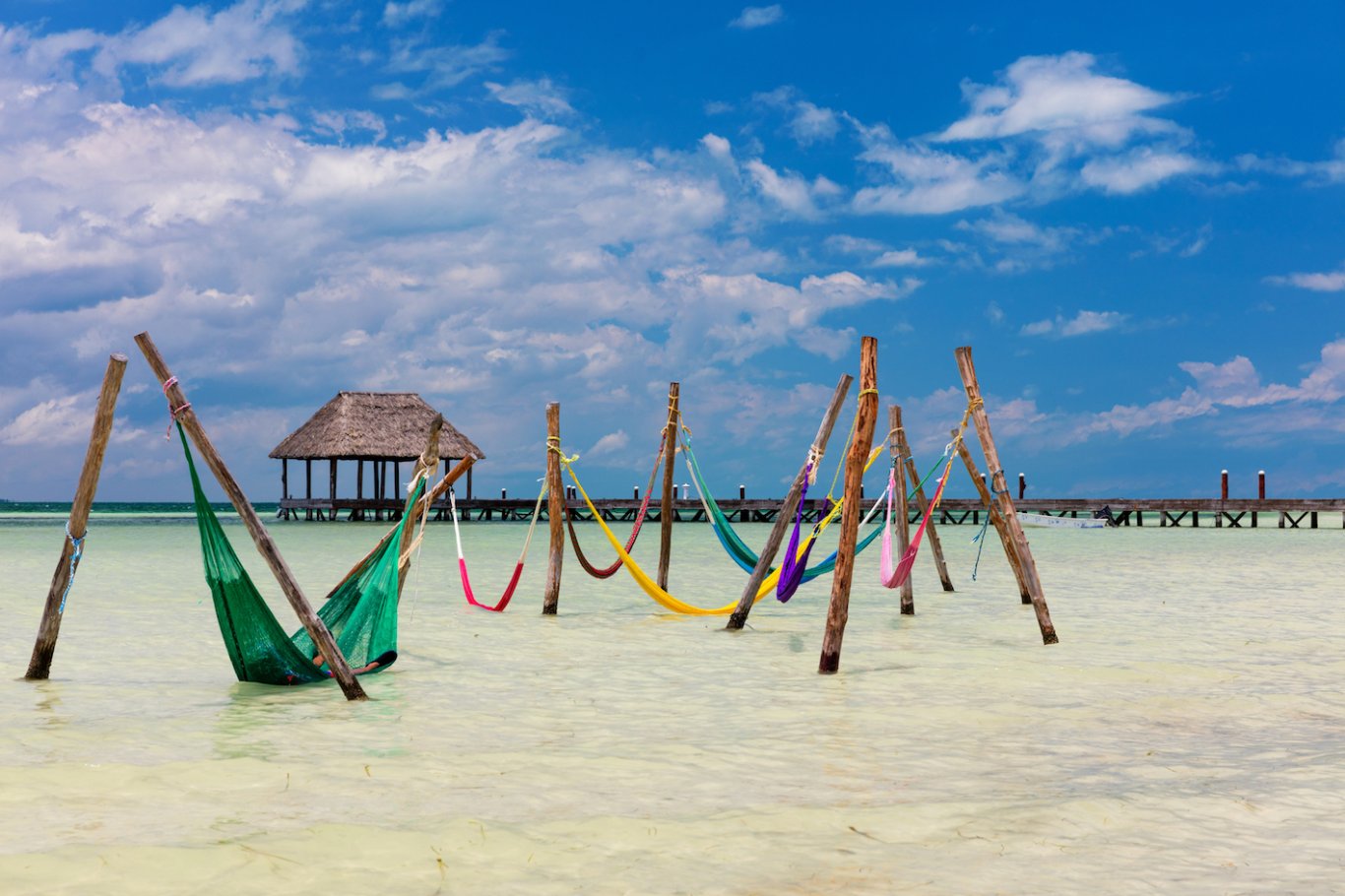 colourful sea hammocks, hut in distance and blue sky