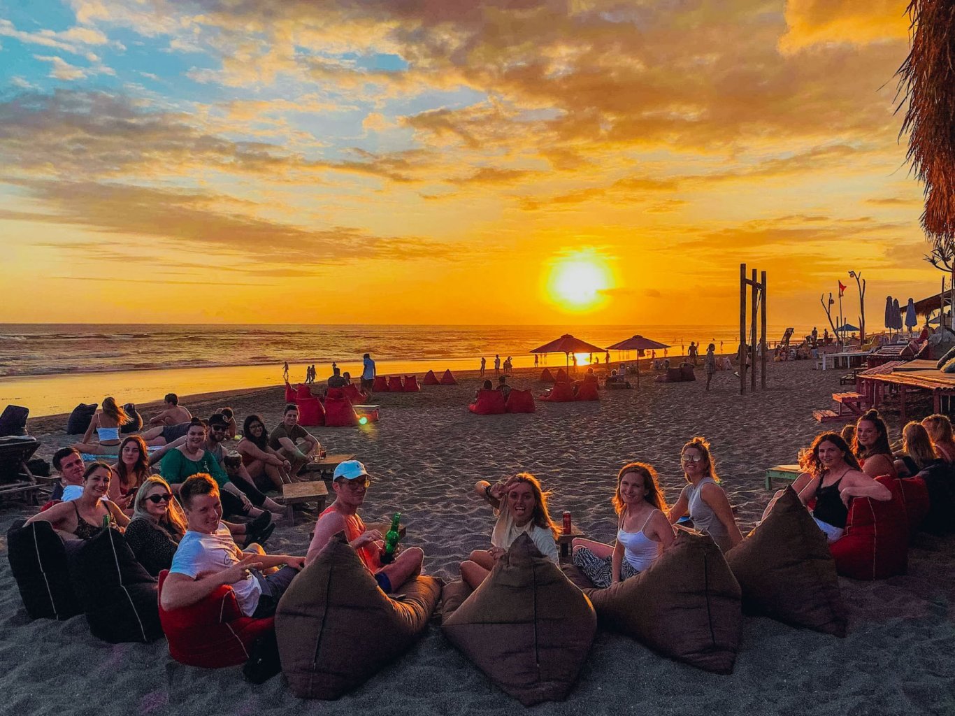 A group shot while lounging in bean bags on the beach, admiring the golden sunset in Bali, Indonesia 