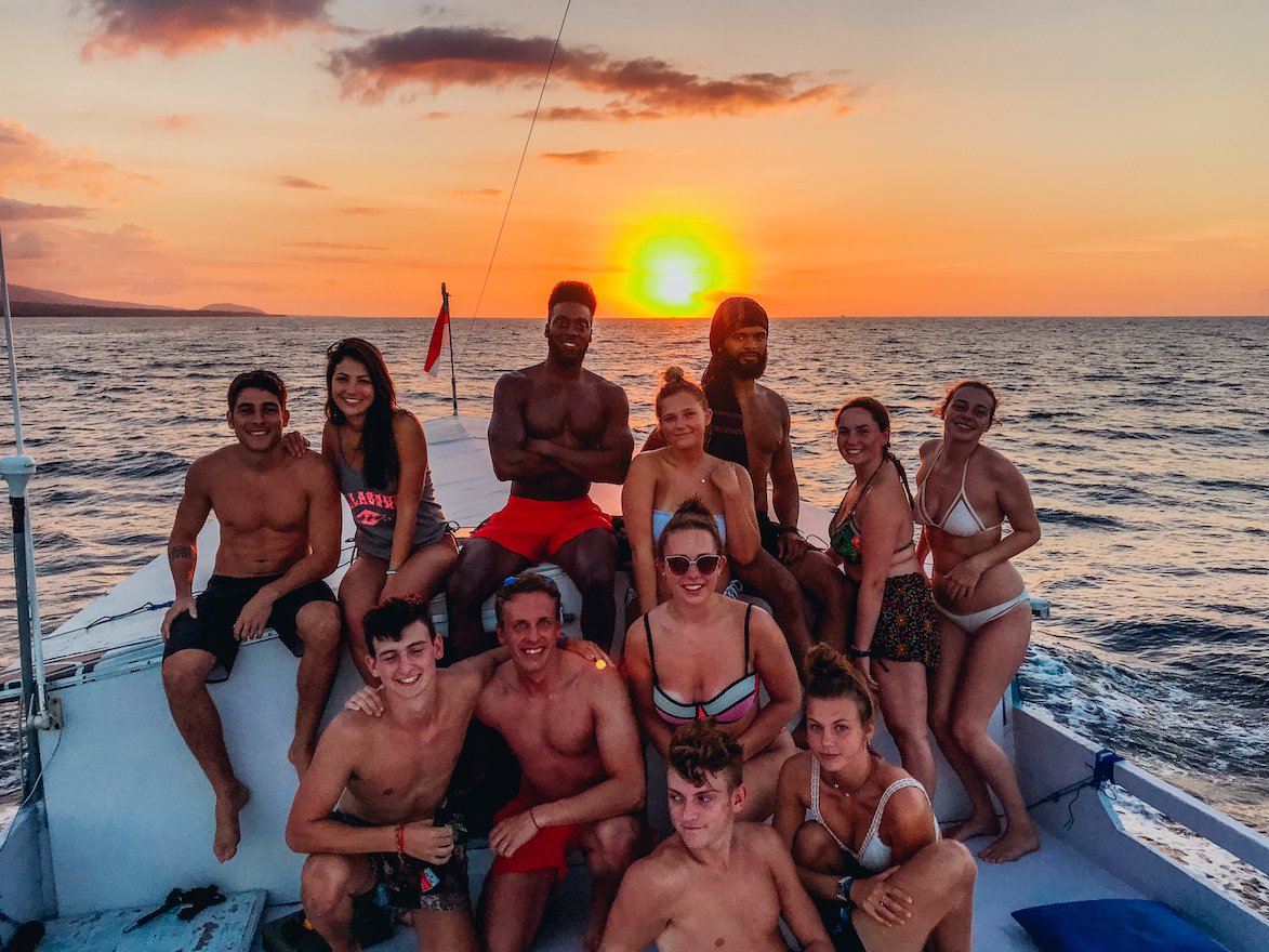 group on live aboard boat with sun going down behind