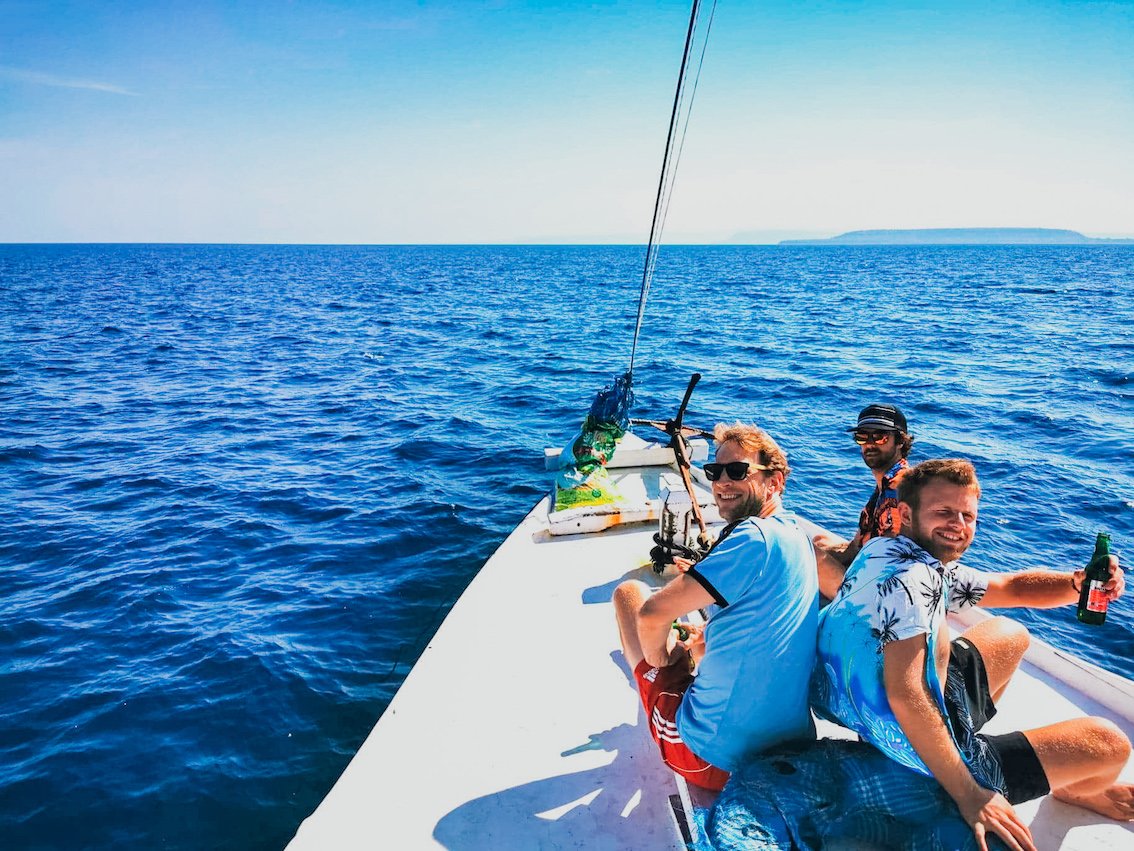 Three guys at the front of the boat when sailing to the Komodo Islands in Indonesia 