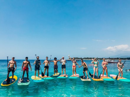 A group paddle boarding on the crystal clear water in Gili Trawangan Indonesia 