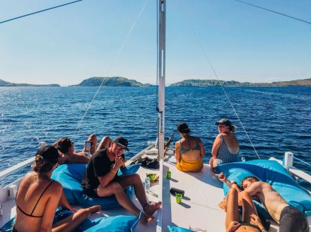 A group relaxing on the deck while sailing to the Komodo Islands in Indonesia 