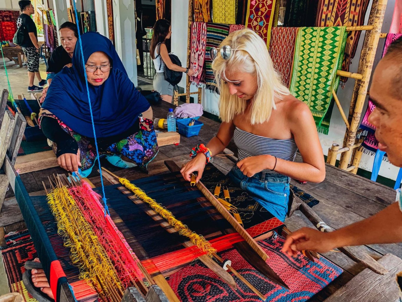 A girl at the Sasak village practicing traditional weaving in Lombok, Indonesia 