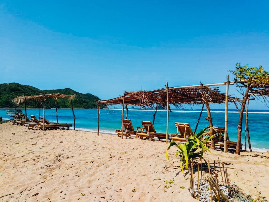 A view of the white sandy beach and crystal clear blue sea in Lombok, Indonesia 