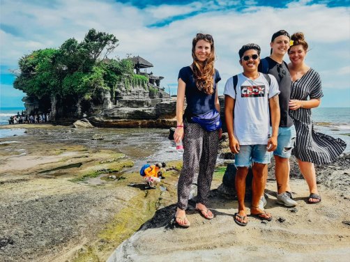 Four people stood in front of the temple Tanah Lot in Indonesia 