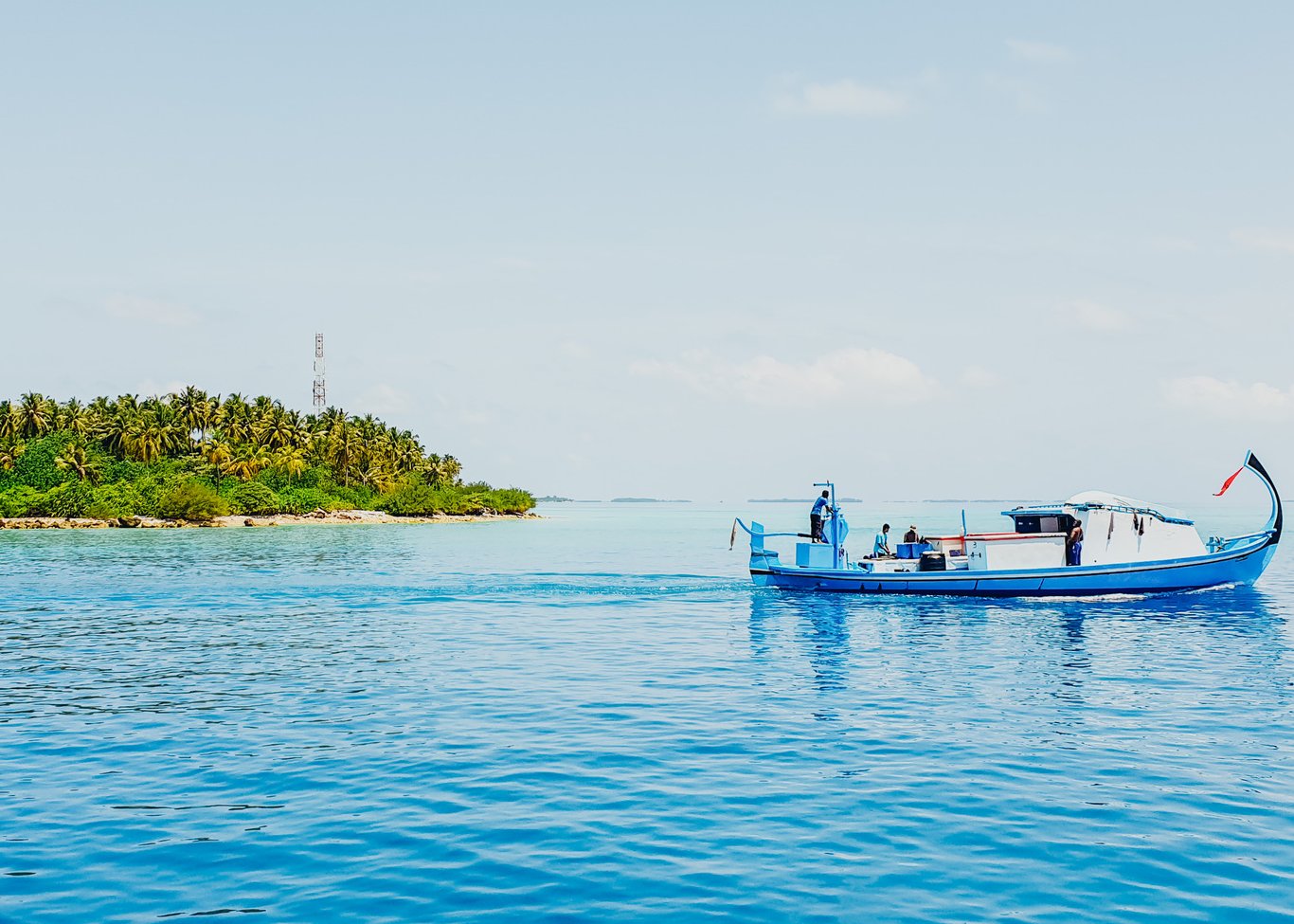 A scenic photo a fishing boat on the blue water in the Maldives 