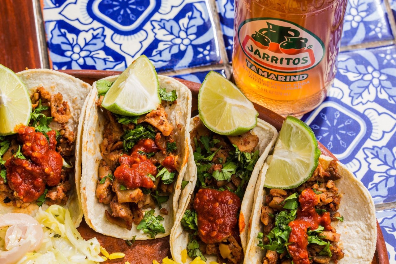 four Tacos with Lime on Colourful blue tiles with Jarritos Mexican Soda