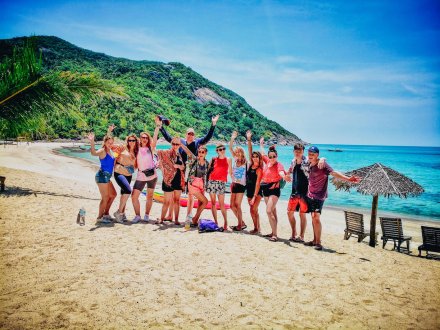 A group in front of the crystal clear blue water at bottle beach Koh Phangan