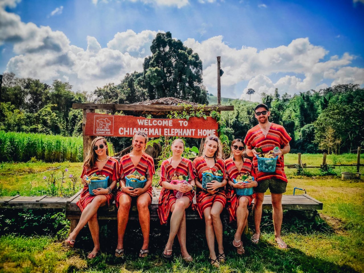 A group photo at the elephant sanctuary in Chiang Mai Thailand while holding buckets of bananas for the elephants