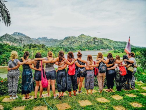 Group of girls with arms round each other facing a viewpoint in Kanchanaburi in Thailand