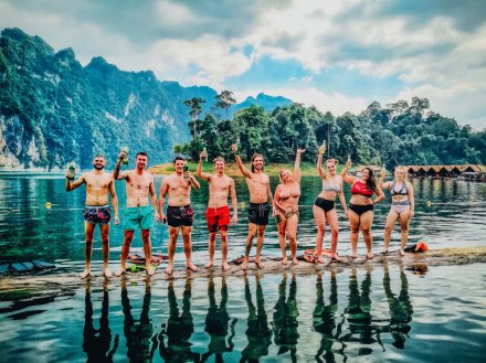 A group photo on a log in the water at Khao Sok national park Thailand