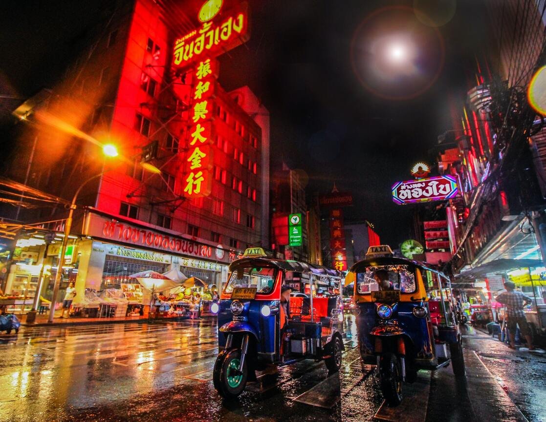 A shot of a busy street in Bangkok, Thailand with tuk tuks and city lights in view 