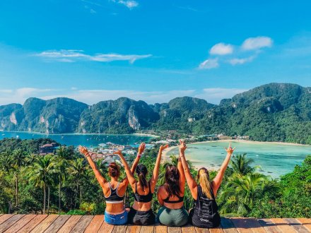 Four girls at the viewpoint in Koh Phi Phi, Thailand overlooking the stunning view of the clear blue ocean and lush greenery