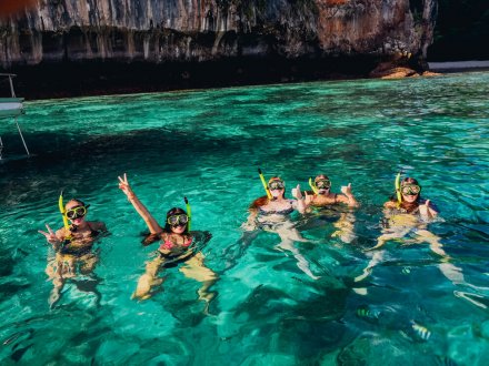 Five people in the crystal clear blue water while snorkelling in Koh Phi Phi, Thailand