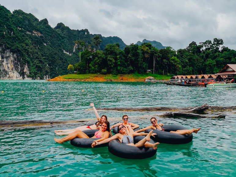 Girls floating in donuts at the lake in Khao Sok National Park Thailand
