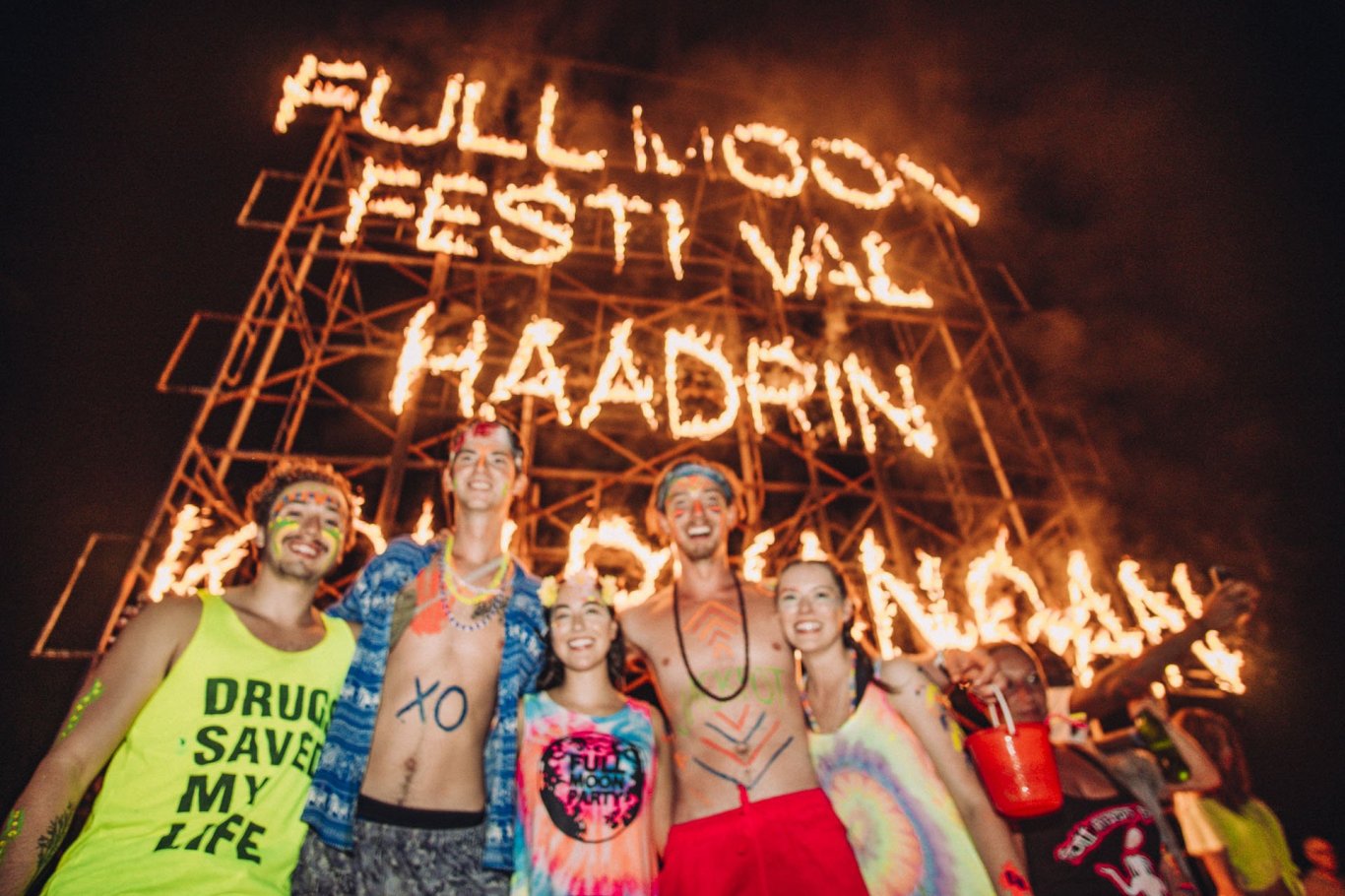 A group photo at the full moon party by a sign made of fire in Koh Phangan Thailand