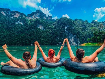 Three people in doughnuts facing the incredible views of Khao Sok in Thailand 