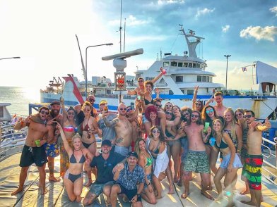 Big group of travellers having fun outside in front of a boat in Thailand