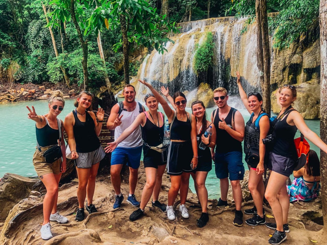 A group arriving at Erawan falls Kanchanaburi Thailand posing for a photo