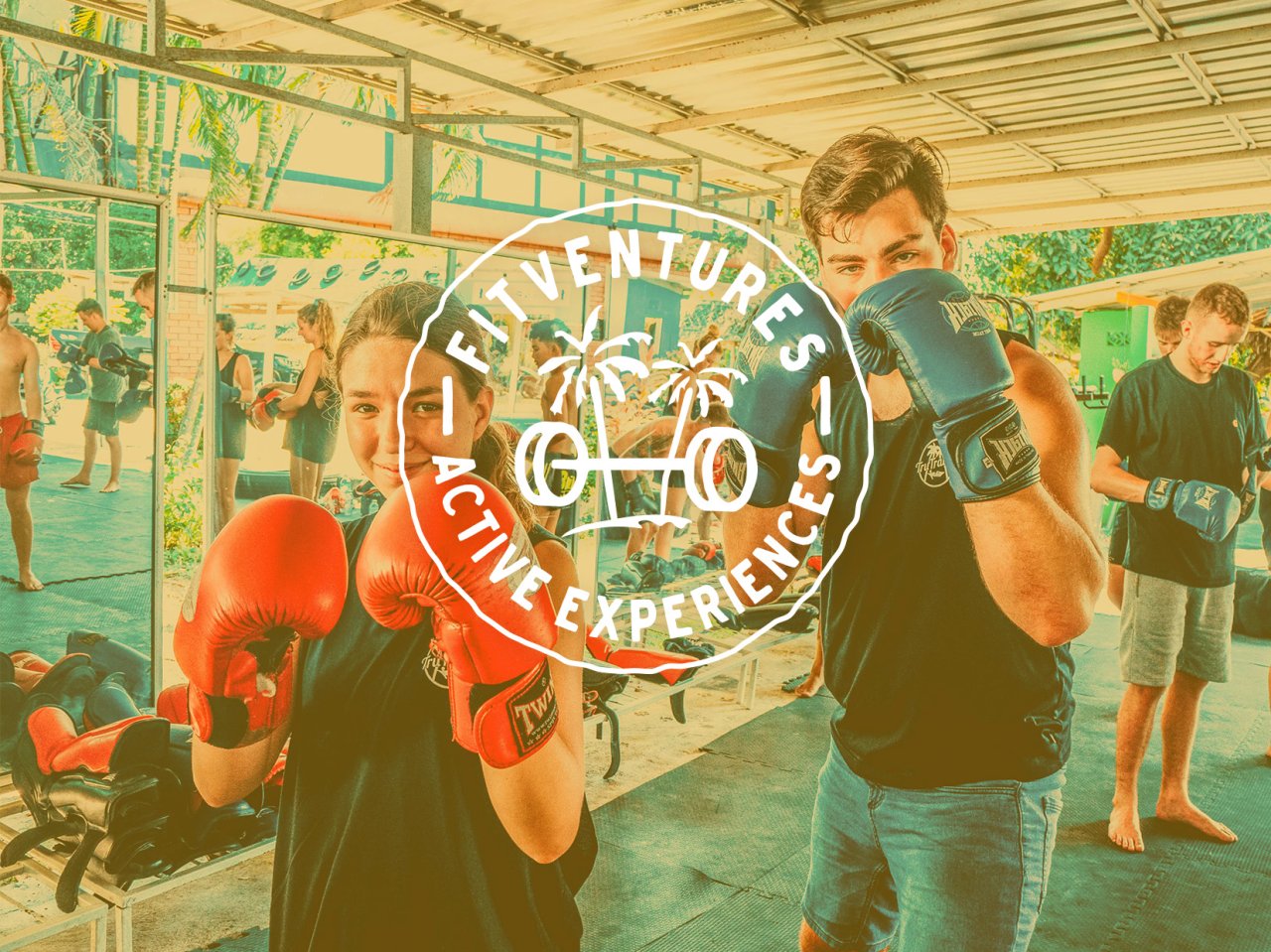 FitVentures Active Experiences text with a background of two people practicing their boxing 